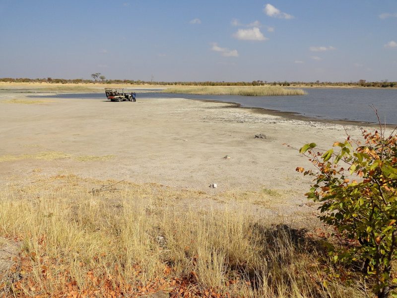 Safari vehicle at a waterhole in Hwange National Park, Zimbabwe